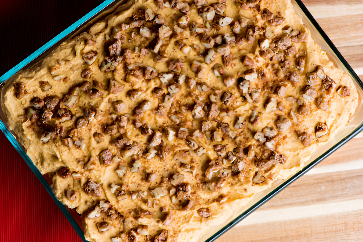 Baked dish topped with chopped nuts in a glass baking dish