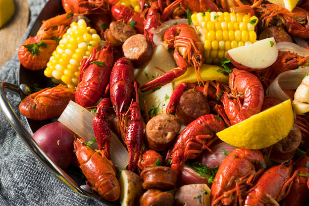 A close-up of a seafood boil featuring crawfish, corn, potatoes, and sausage in a serving dish.