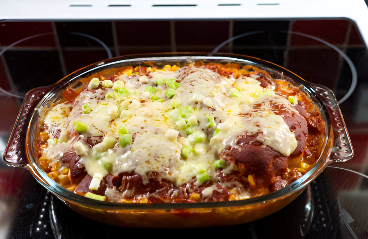 A baked dish with melted cheese, chopped green onions, and a colorful mixture of ingredients.