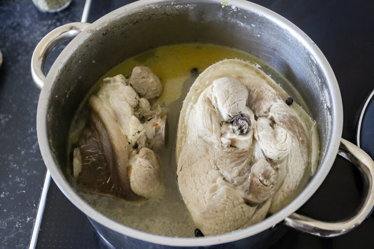 A pot with boiled meat pieces submerged in broth.