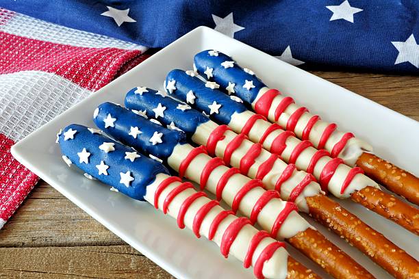 A plate of pretzel rods dipped in red, white, and blue chocolate, resembling the American flag.