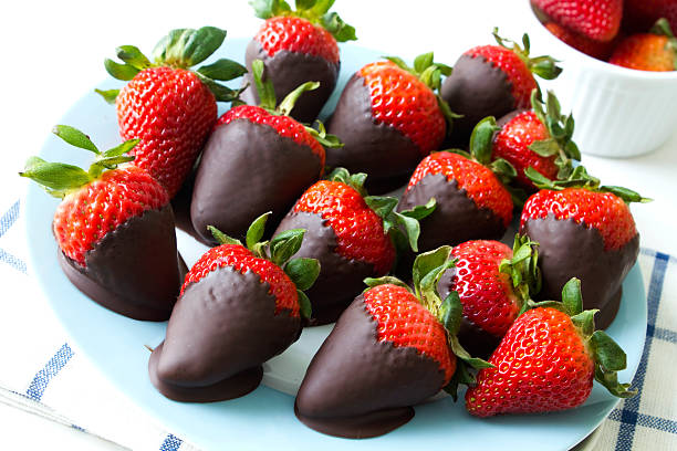 A plate of chocolate-covered strawberries arranged appetizingly.