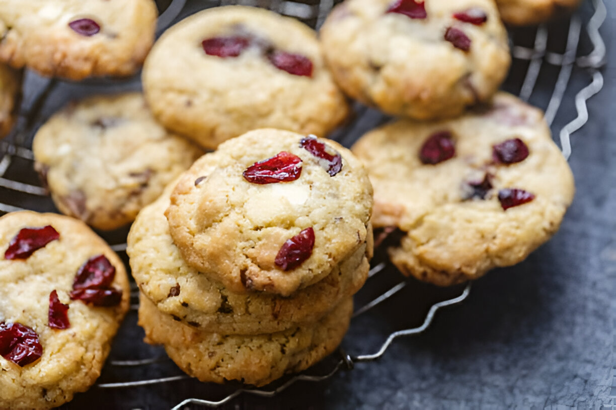 Close-up of a stack of cookies with dried cranberries on a wire rack.