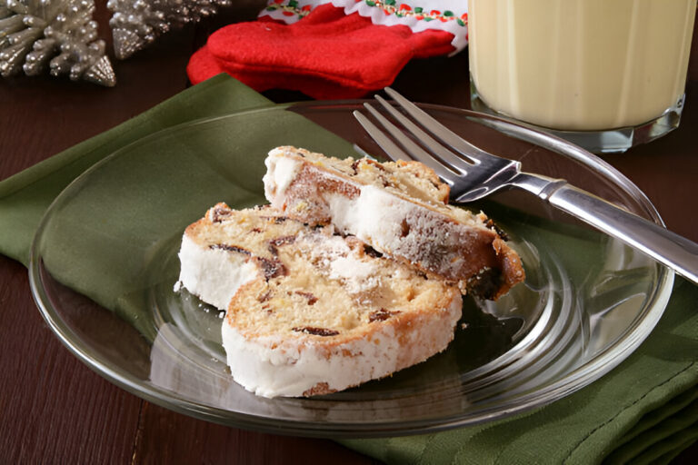 Two slices of a dessert on a glass plate with a fork, set on a green napkin.