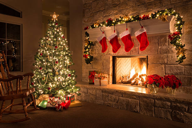 A cozy living room decorated for Christmas with a brightly lit tree, stockings on the fireplace, and festive gifts.