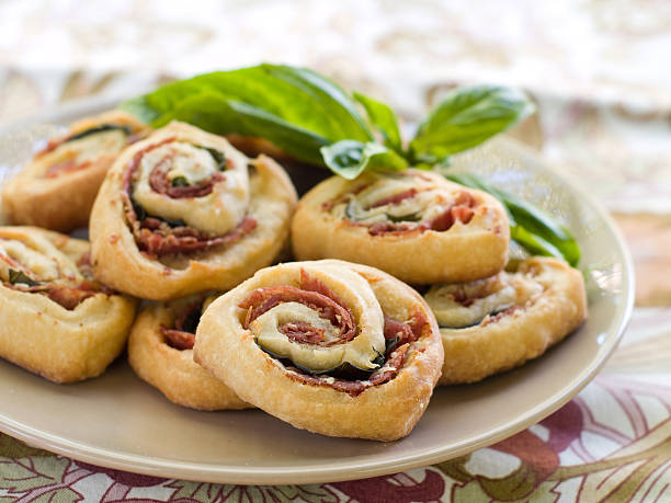 A platter of savory roll pastries filled with basil and tomato.