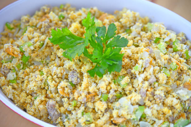 A close-up of a bowl of stuffing with herbs and vegetables