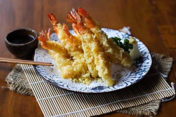 Plate of shrimp tempura with dipping sauce and chopsticks