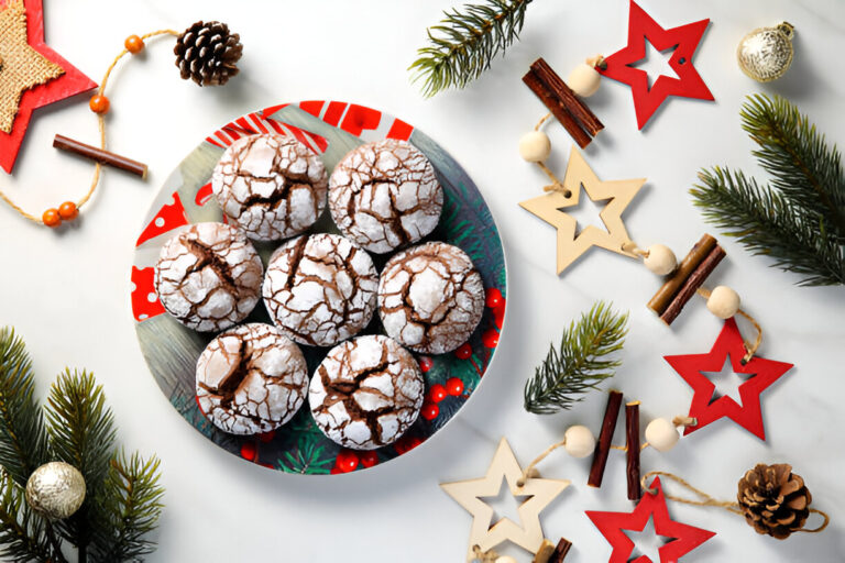 A decorative plate filled with cracked chocolate cookies, surrounded by festive decor including pine branches, wooden stars, and a pine cone.