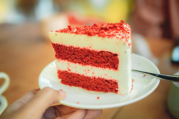 A slice of red velvet cake with cream cheese frosting on a white plate