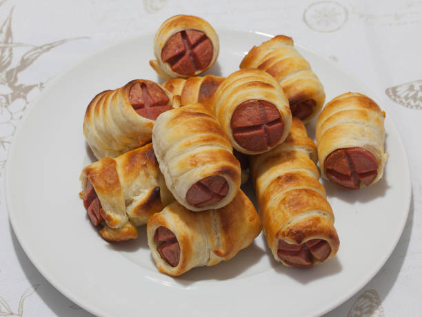 A plate of freshly baked sausage rolls arranged neatly.