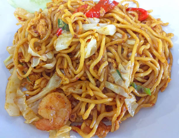 A plate of stir-fried noodles with shrimp and vegetables