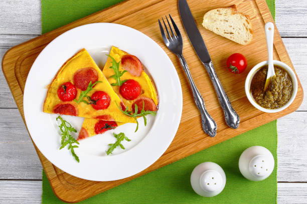 Plate of frittata with radish, cherry tomatoes, and arugula on a wooden serving tray.