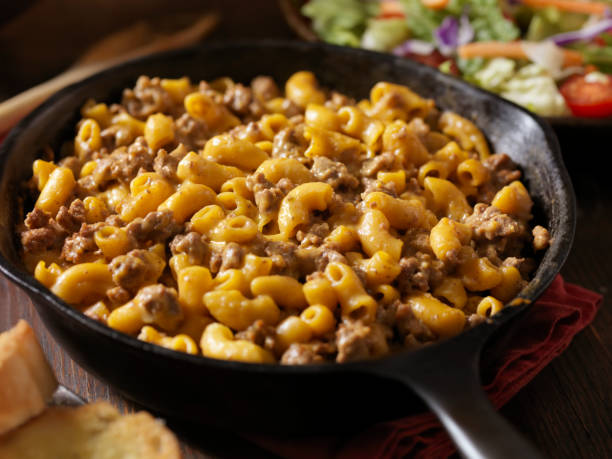 A serving of macaroni and cheese with ground beef in a cast iron skillet.