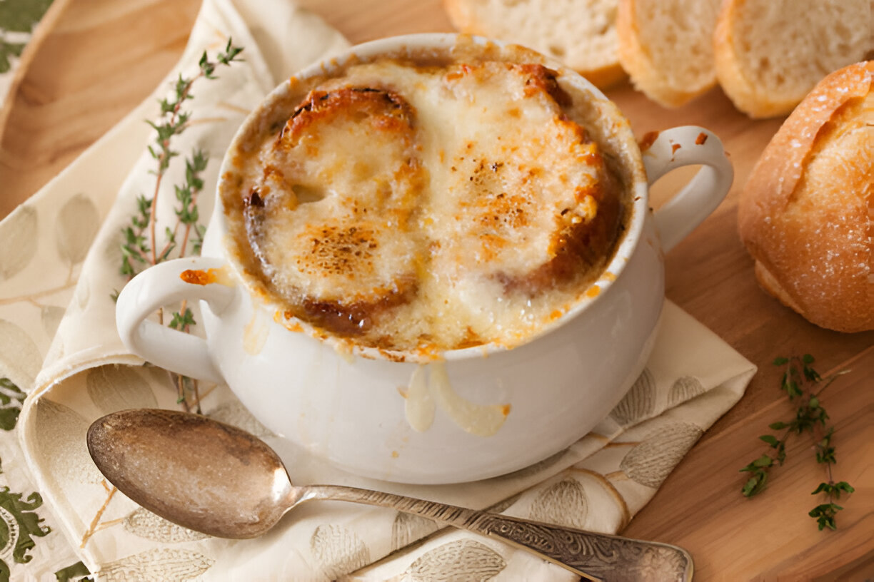 A bowl of bubbling French onion soup topped with melted cheese and toasted bread.