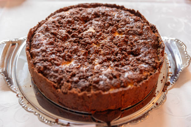 A delicious baked cake with a crumbly topping on a silver platter.