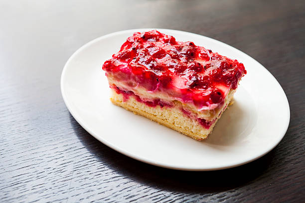 A slice of layered berry cheesecake on a white plate