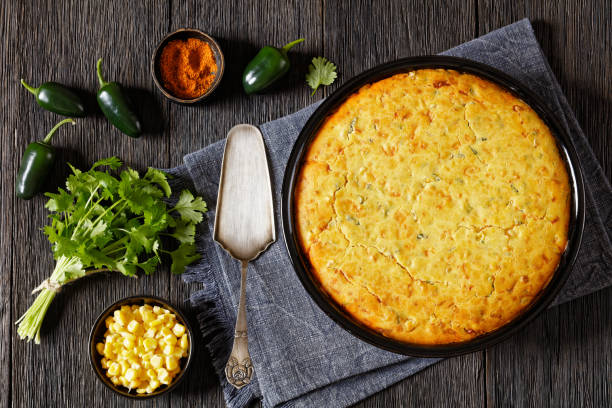 A freshly baked cornbread surrounded by fresh cilantro, corn, and jalapeños.