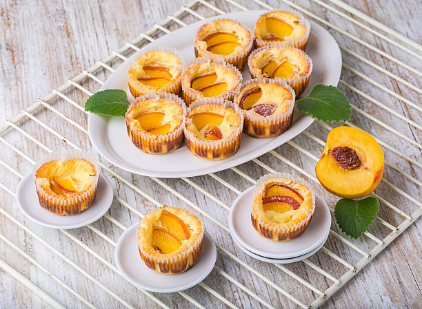 Mini peach tarts arranged on a white platter and small plates on a wire rack.