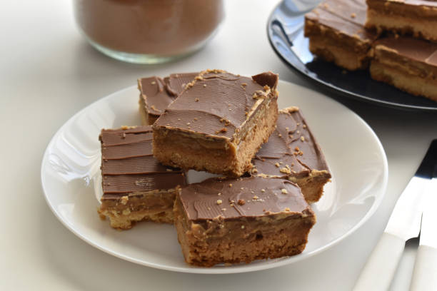 A plate of sliced chocolate caramel bars with a smooth chocolate topping