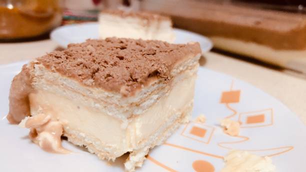 A close-up view of a slice of layered dessert on an orange patterned plate.