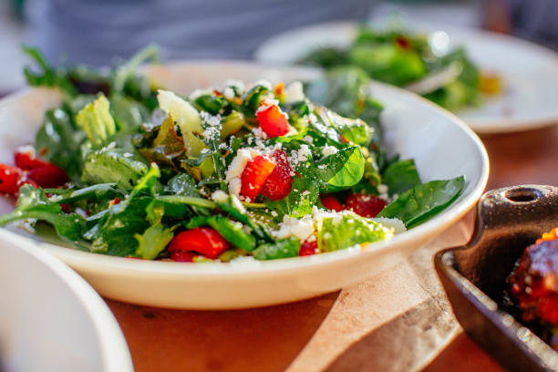 A fresh salad with mixed greens, cherry tomatoes, and cheese on a plate.