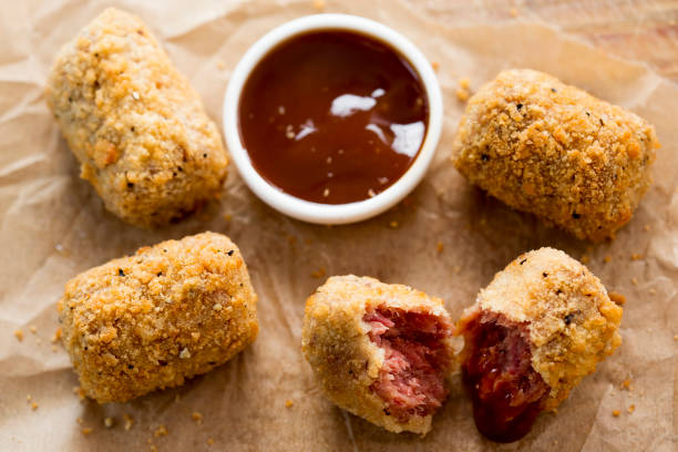 Crispy breaded meat snacks with a side of barbecue sauce