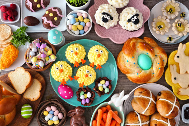 A vibrant spread of colorful Easter-themed treats including cupcakes, cookies, and chocolates arranged on a rustic wooden table.