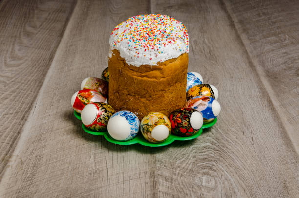 A festive Easter cake topped with colorful sprinkles, surrounded by decorative Easter eggs on a green plate.