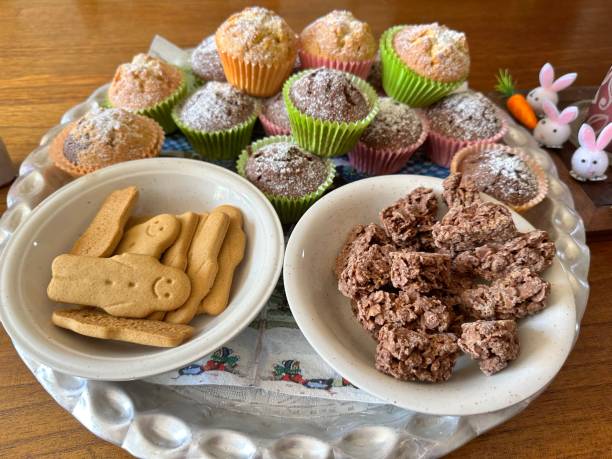 A decorative platter showcasing colorful muffins and two bowls of snacks.