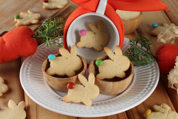 A plate with wooden bowls containing bunny-shaped cookies, surrounded by decorative items.