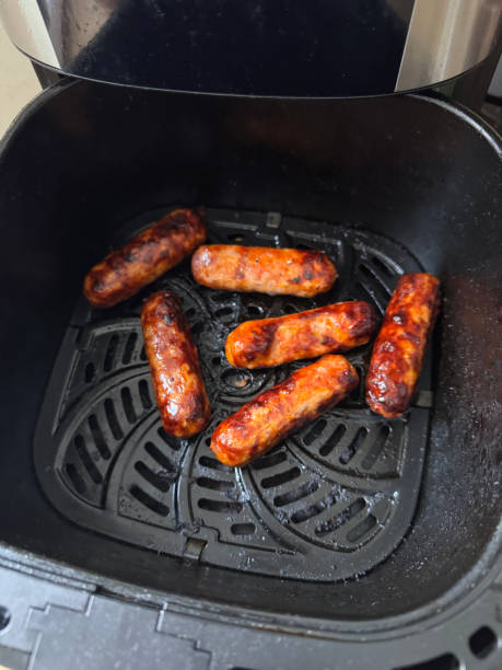 Cooked sausages in an air fryer basket