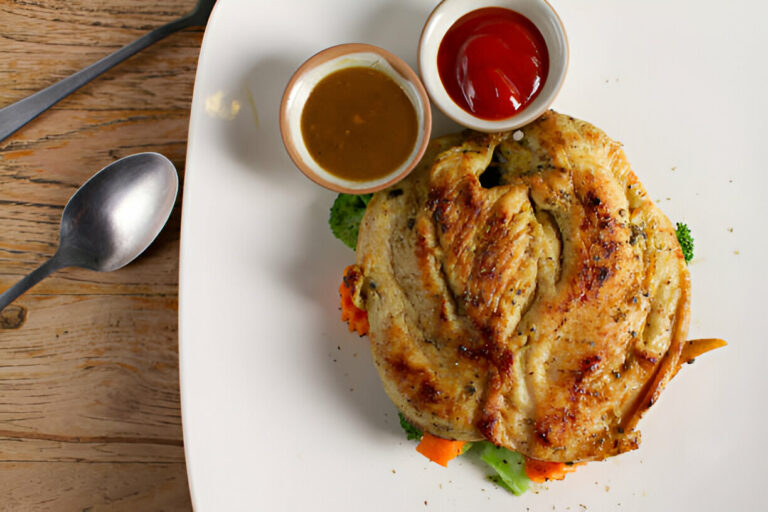 A plated dish featuring grilled chicken served with sauces and vegetables.