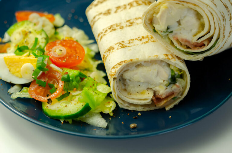 Delicious wraps with a fresh garden salad on a blue plate.