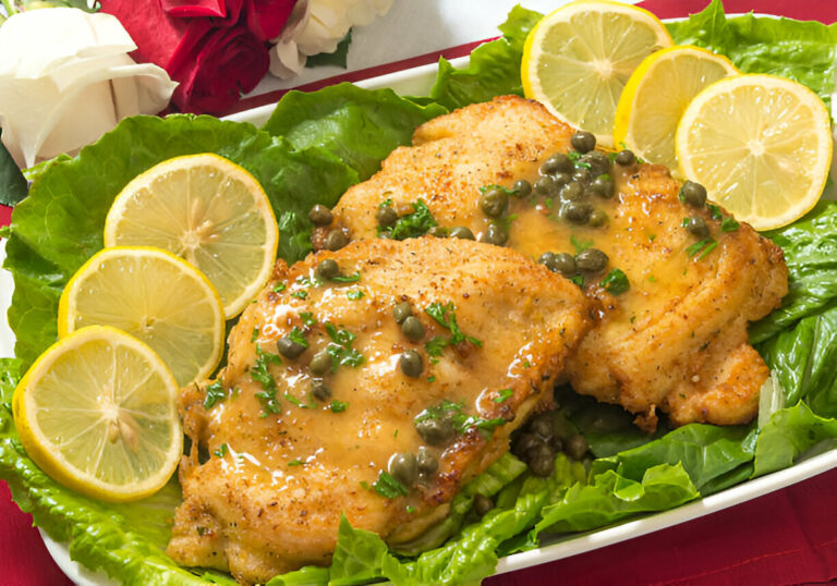 Delicious chicken dish served on lettuce with lemon slices and capers