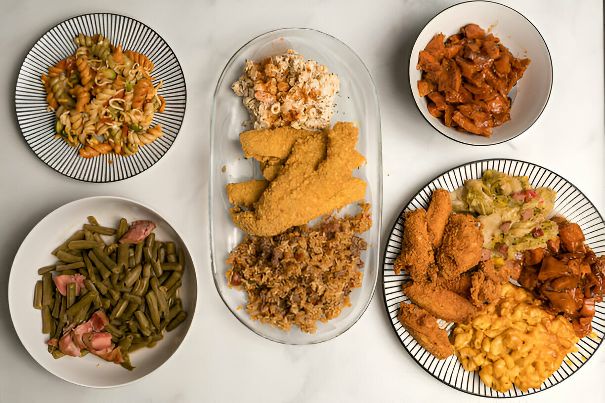 An assortment of delicious home-cooked meals displayed on plates, including chicken, rice, pasta, green beans, and other sides.