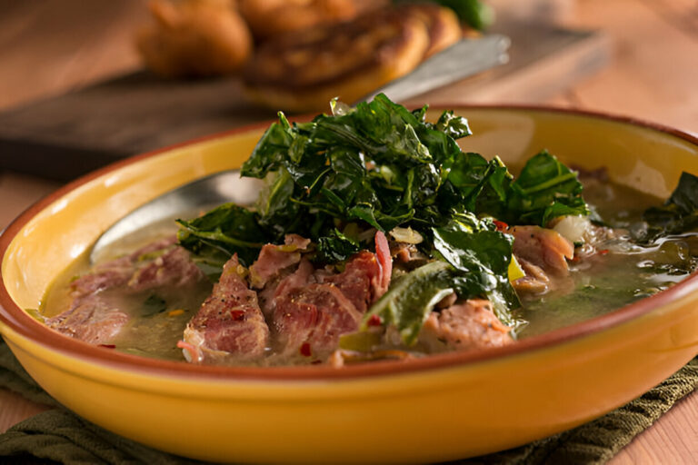 A vibrant yellow bowl filled with a savory soup featuring chunks of meat and fresh greens on top, served on a rustic table.