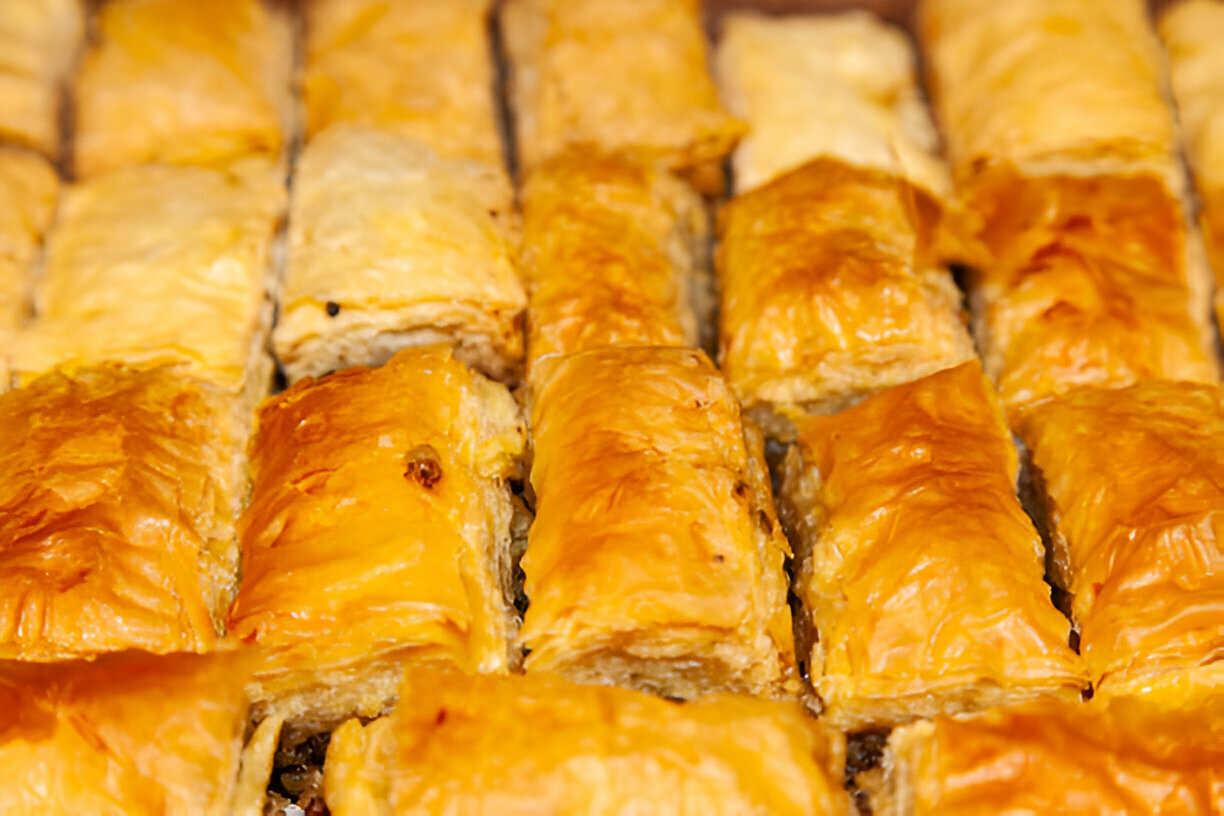 Close-up of freshly baked dessert squares with flaky golden pastry.