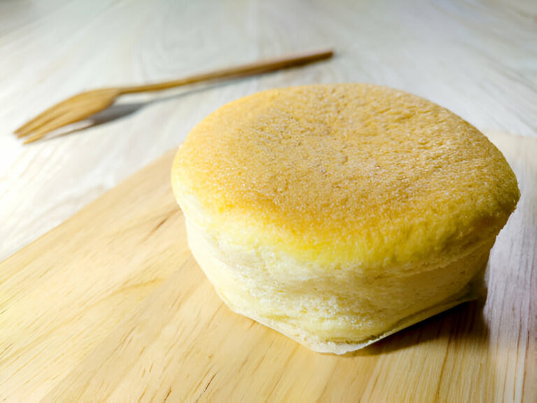 Fluffy Japanese pancake on a wooden cutting board with a fork in the background