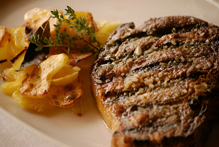 A beautifully cooked steak served with roasted potatoes and garnished with fresh herbs.