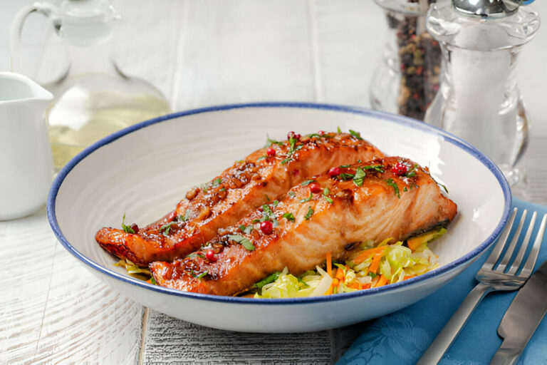 Grilled salmon fillets served on a bed of salad with colorful vegetables