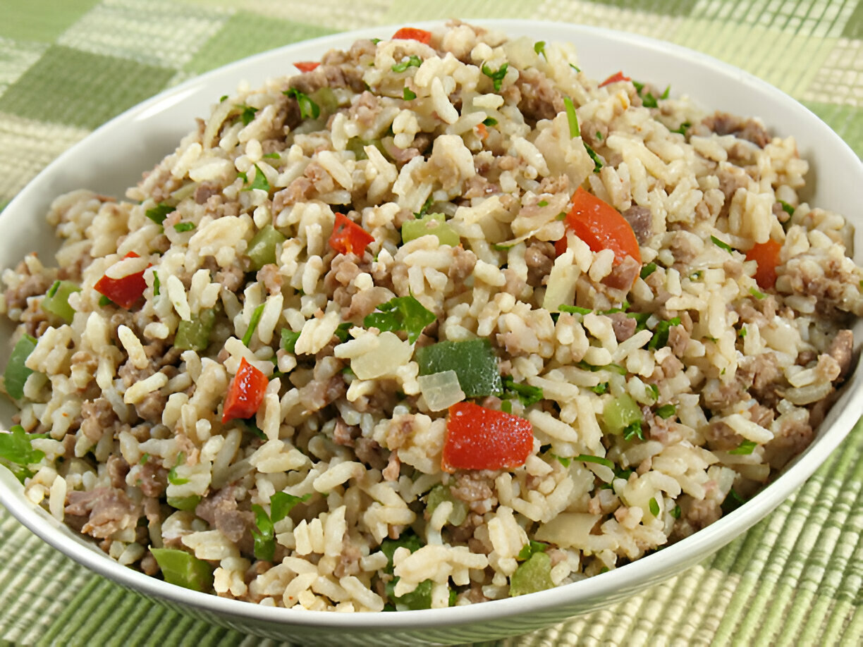 A bowl of rice mixed with ground meat and vegetables, garnished with herbs.