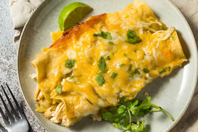 Delicious cheese enchiladas topped with cilantro and served with a lime wedge