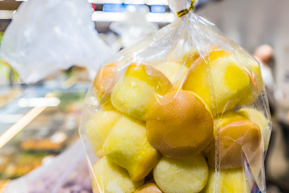 A transparent bag filled with colorful sweet treats, showcasing a variety of round and square shaped confections.