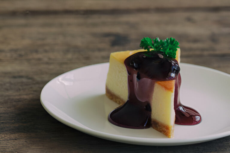 A slice of cheesecake topped with berry sauce on a white plate.