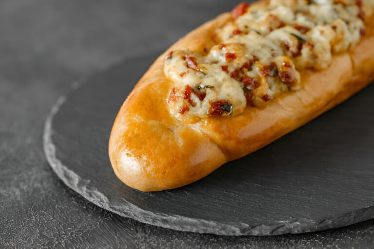 A delicious cheese-filled bread loaf on a slate serving board.