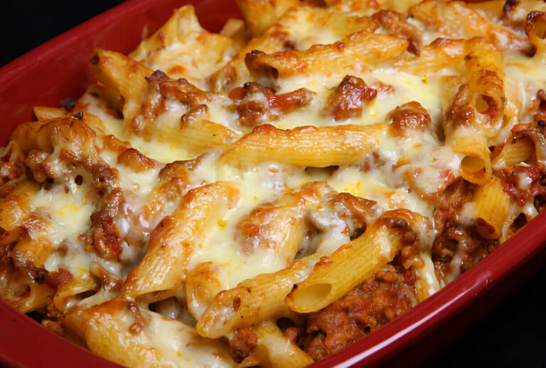 Baked pasta with cheese and meat sauce in a red dish