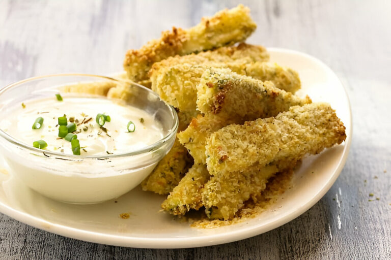 Golden brown zucchini fries served with a creamy dipping sauce garnished with green onions