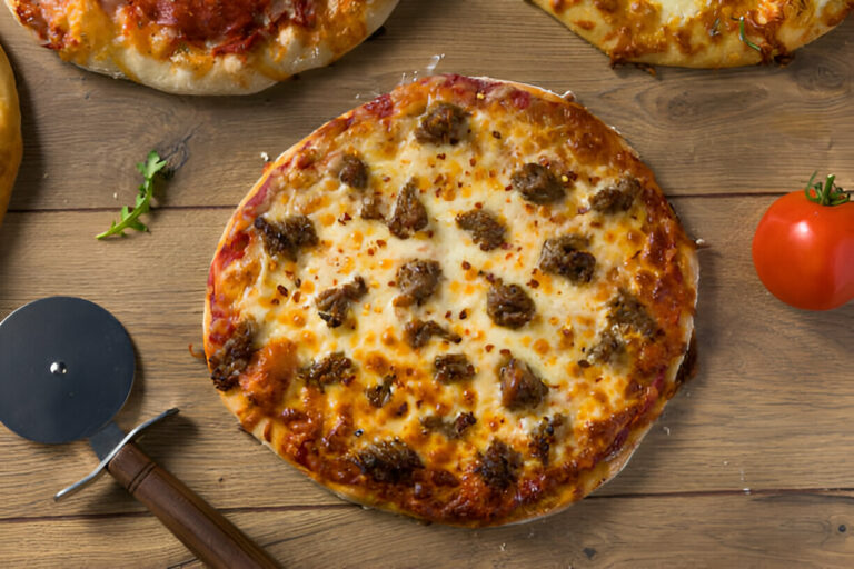 A freshly baked pizza topped with cheese and meat on a wooden surface.